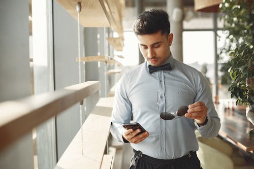 Man In Blue Dress Shirt Holding Black Smartphone