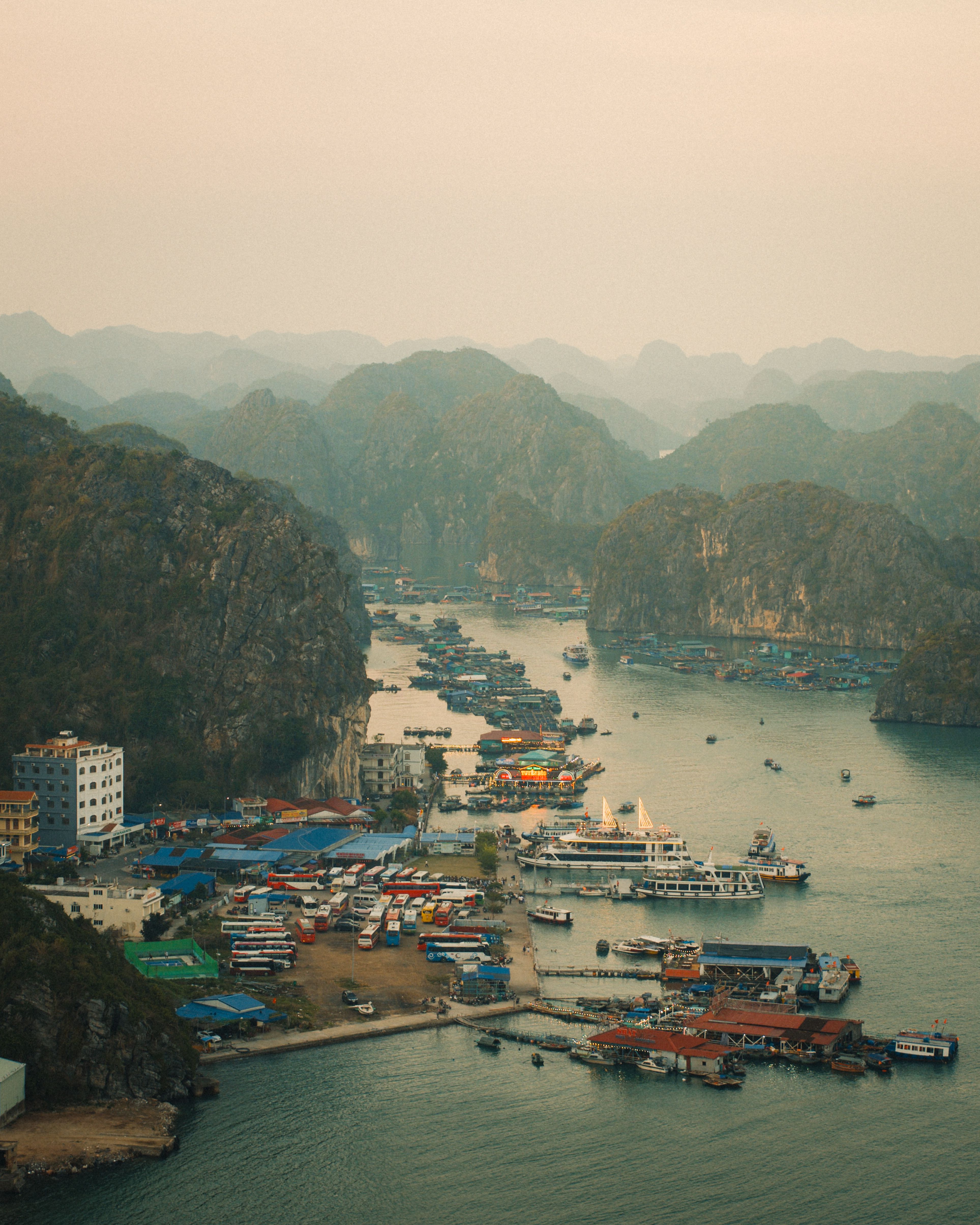 Captivating aerial view of a coastal village amid karst islets in a serene bay at daybreak.