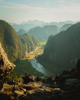 A stunning view of a river valley surrounded by dramatic limestone mountains under a clear blue sky.