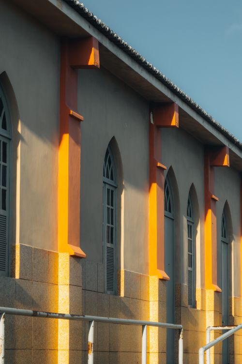 Free Side view of a historic church exterior with orange accents and arched windows in Natal, Brazil. Stock Photo