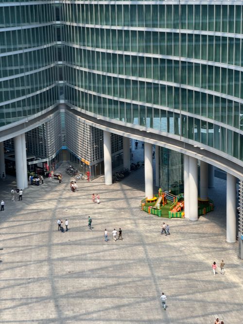 Free People walking in a sunlit architectural plaza in Milan's urban center. Stock Photo
