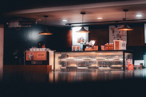 Free Warm-lit cafe interior showcasing pastries and beverages, creating a cozy atmosphere in Shoolagiri, India. Stock Photo