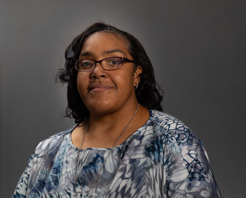 Free Studio portrait of a smiling woman wearing eyeglasses and a colorful blouse. Stock Photo