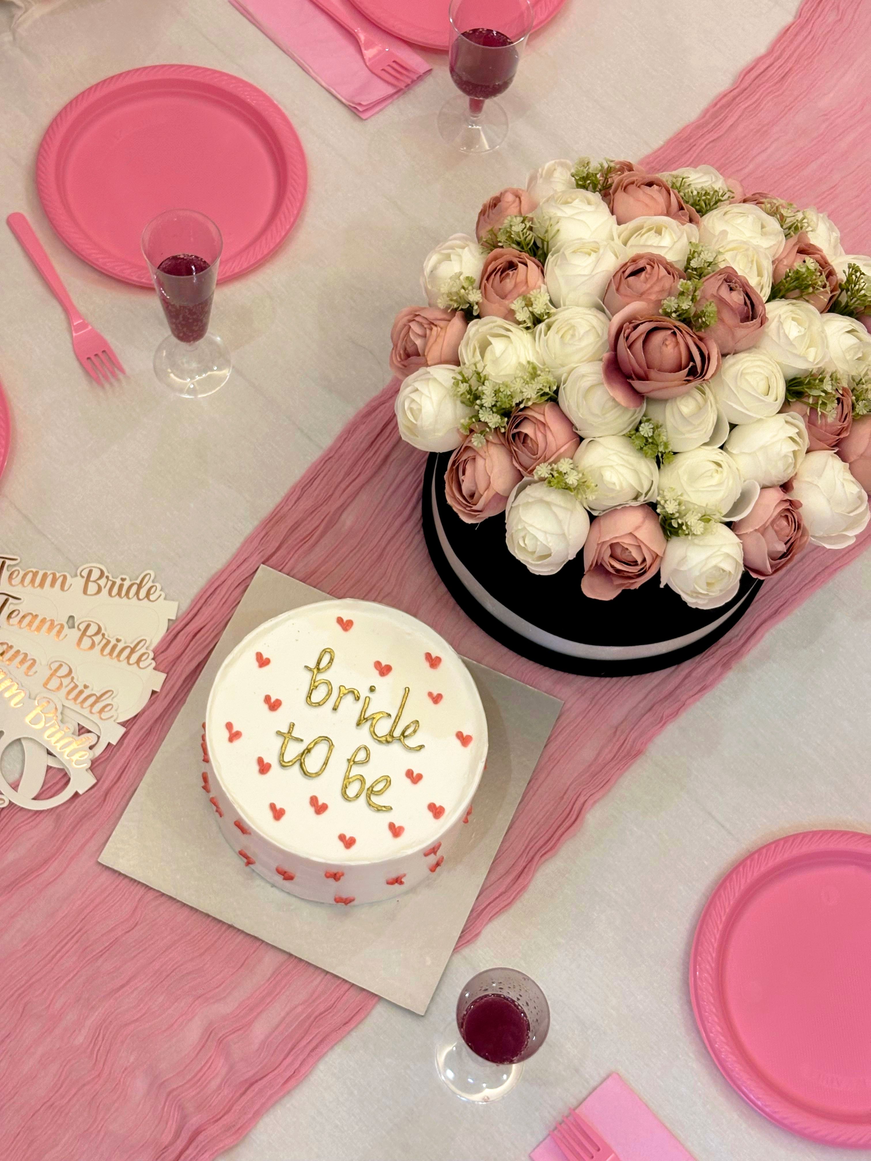 A beautiful bridal shower setup featuring a 'bride to be' cake and floral centerpiece.