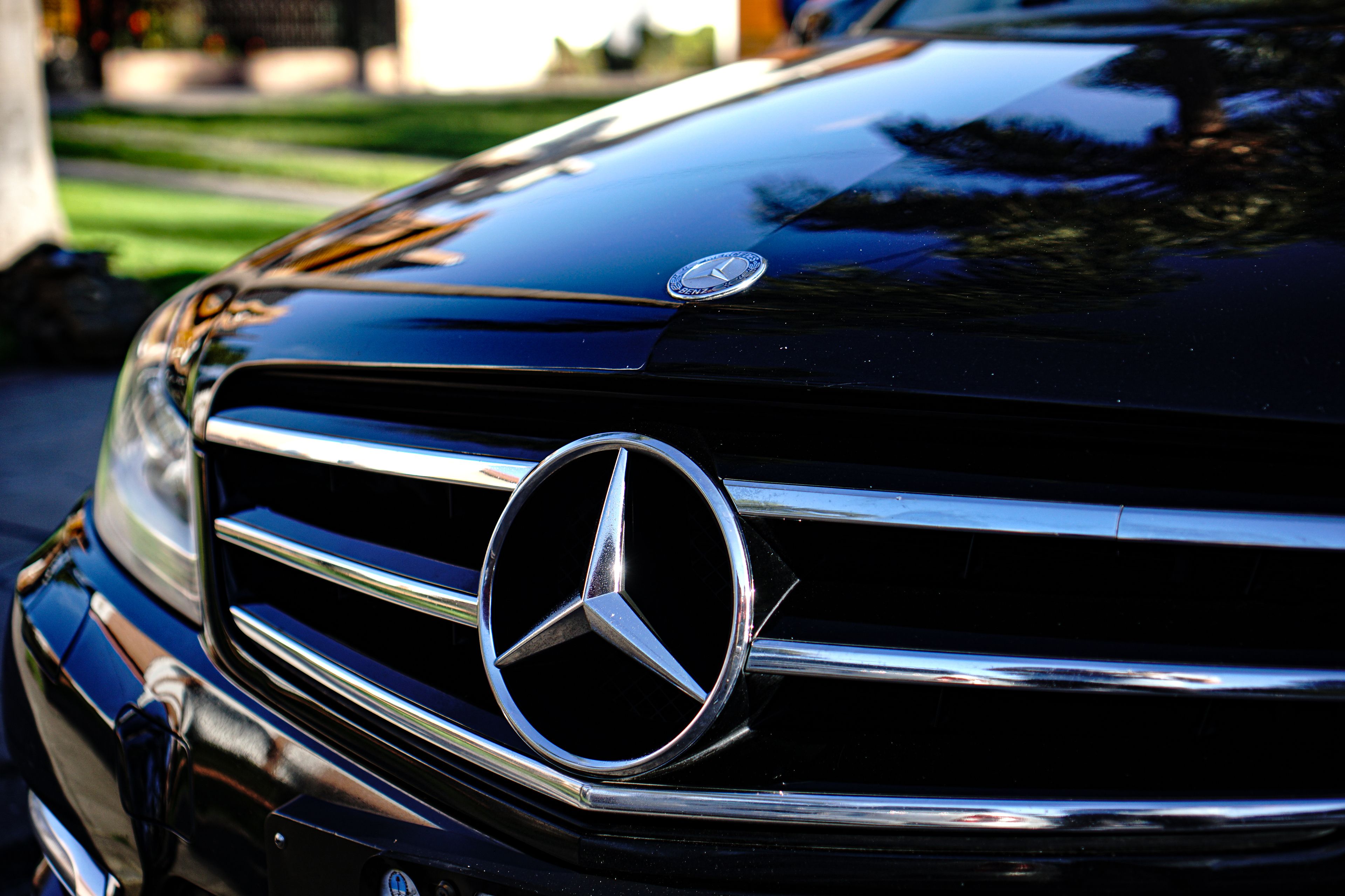A luxury chauffeur-driven car waiting outside a private entrance