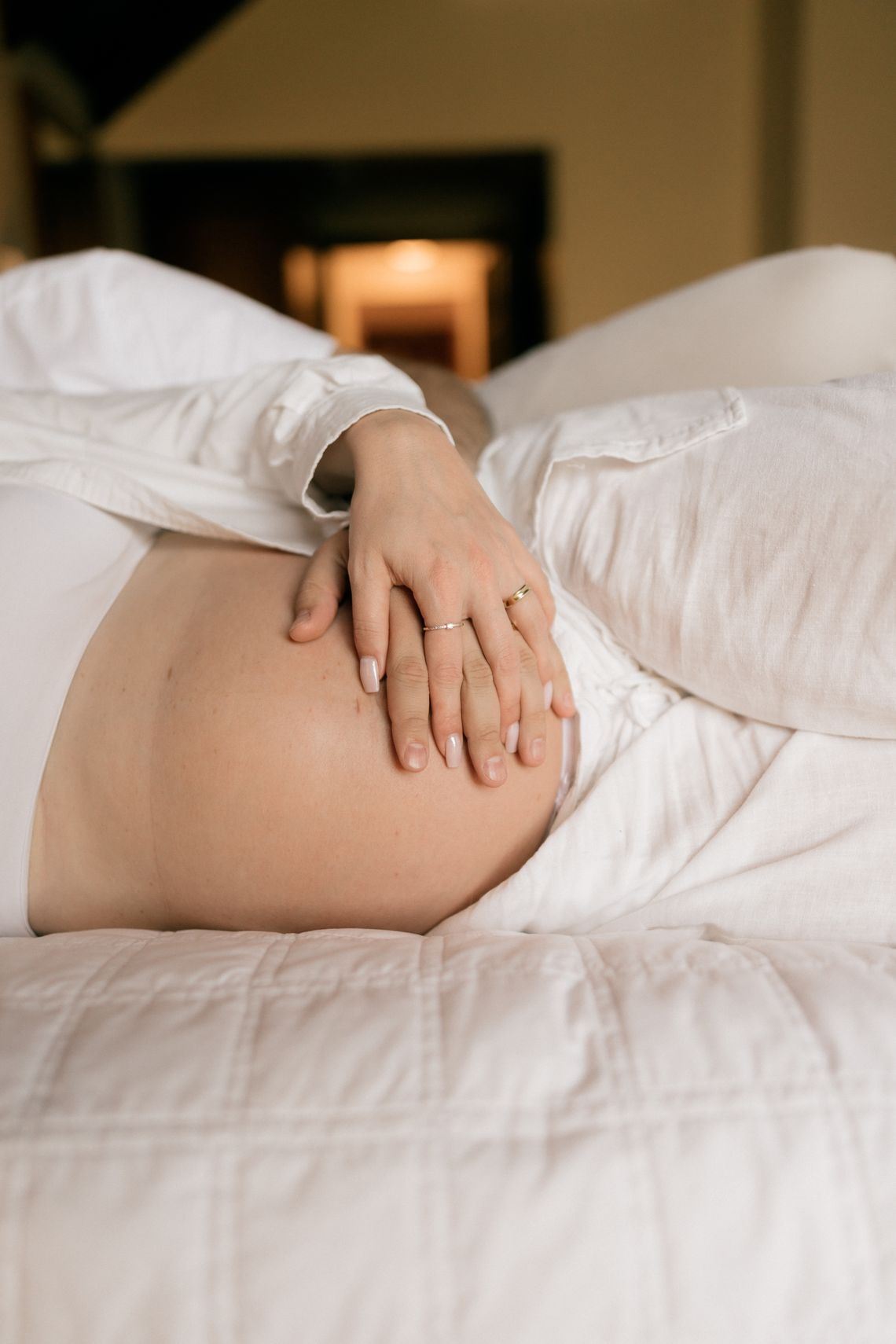 Pregnant woman resting comfortably on a soft bed