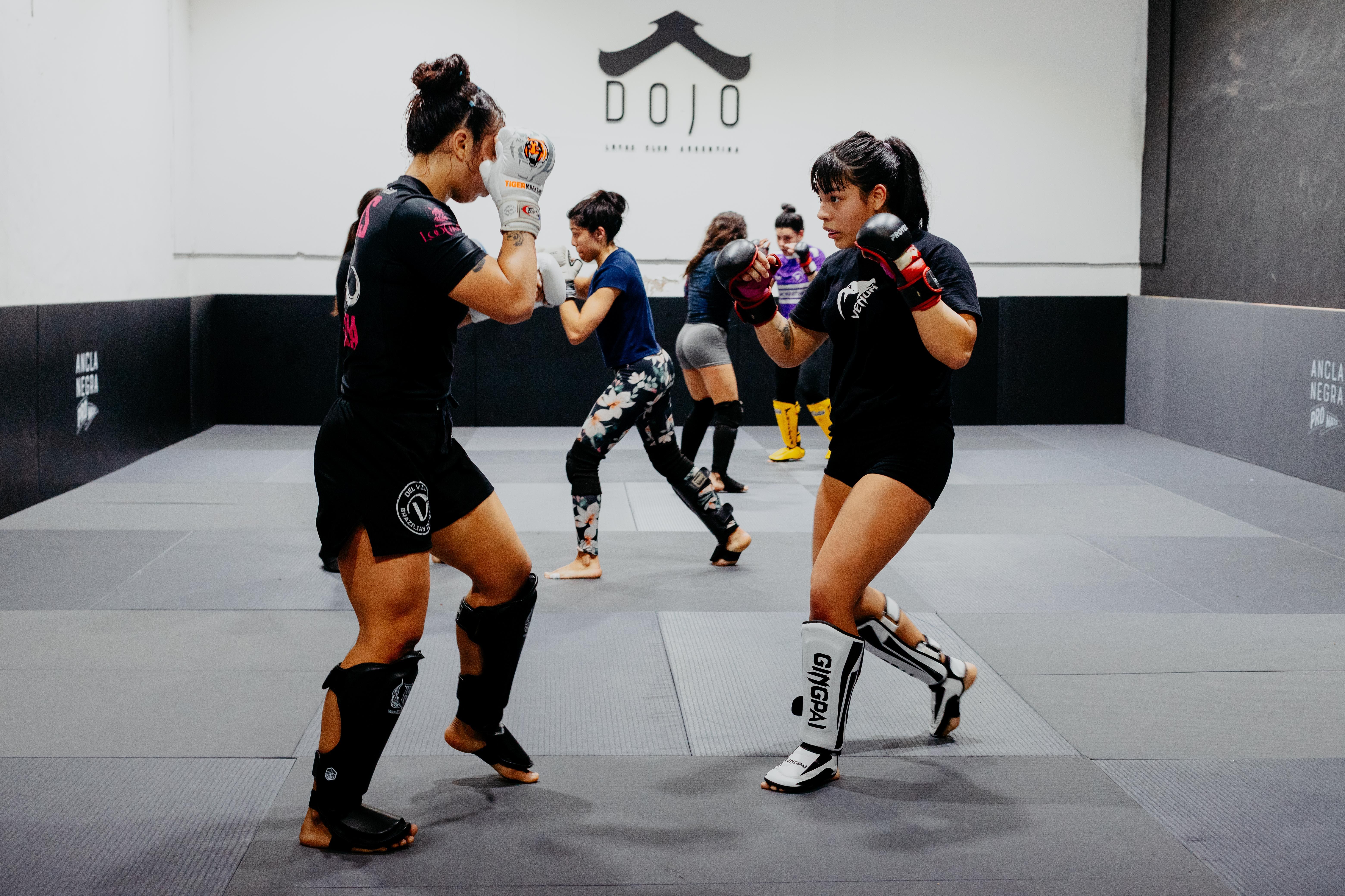 Female martial artists engage in sparring practice at a Buenos Aires dojo, Argentina.
