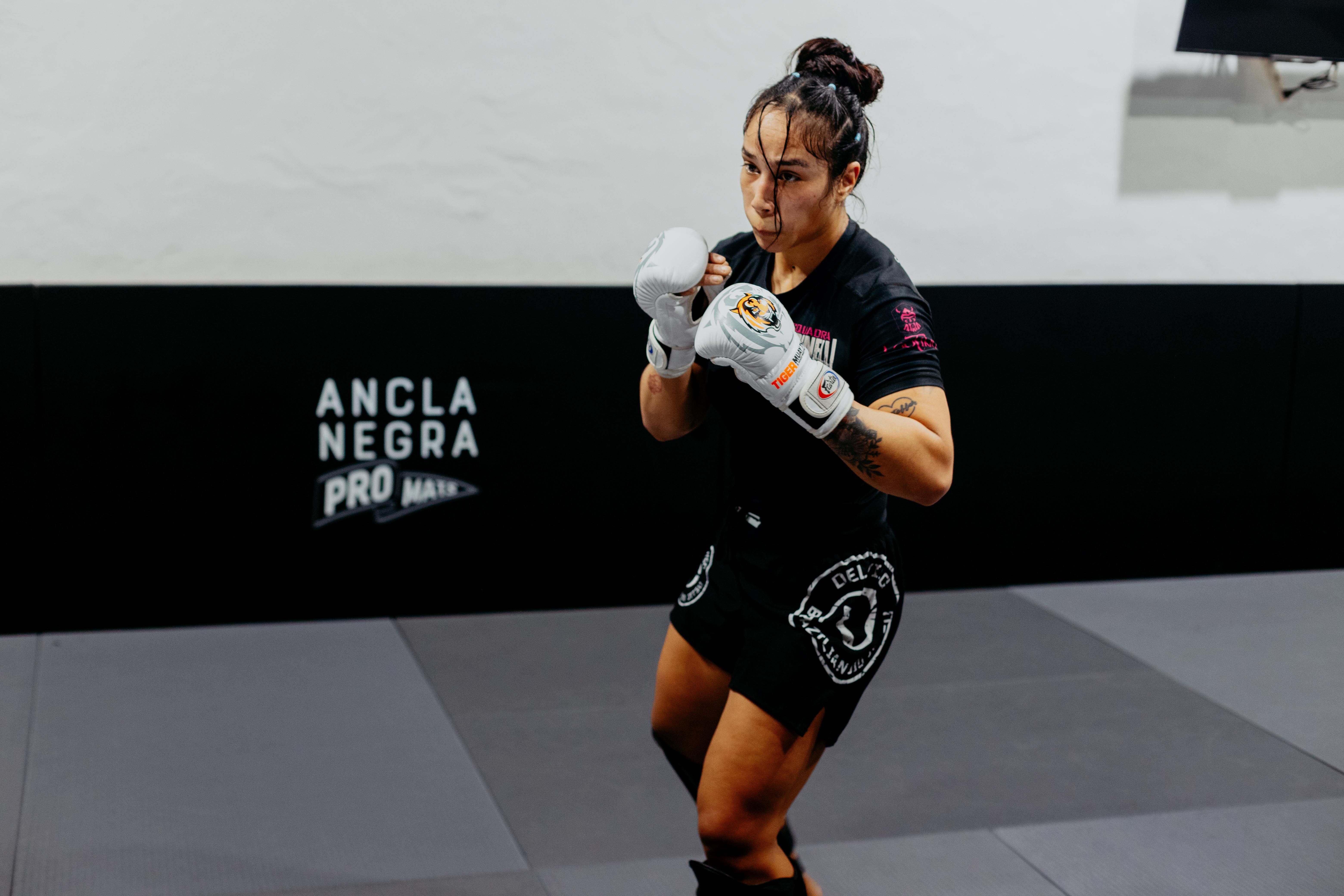 Focused female martial artist practicing in Buenos Aires gym. Strength and determination captured indoors.