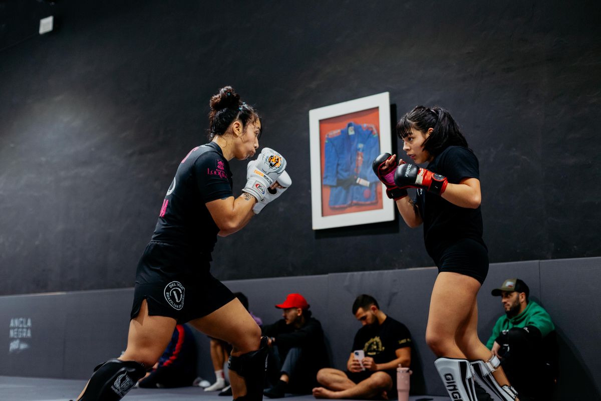 Two women training MMA in the gym