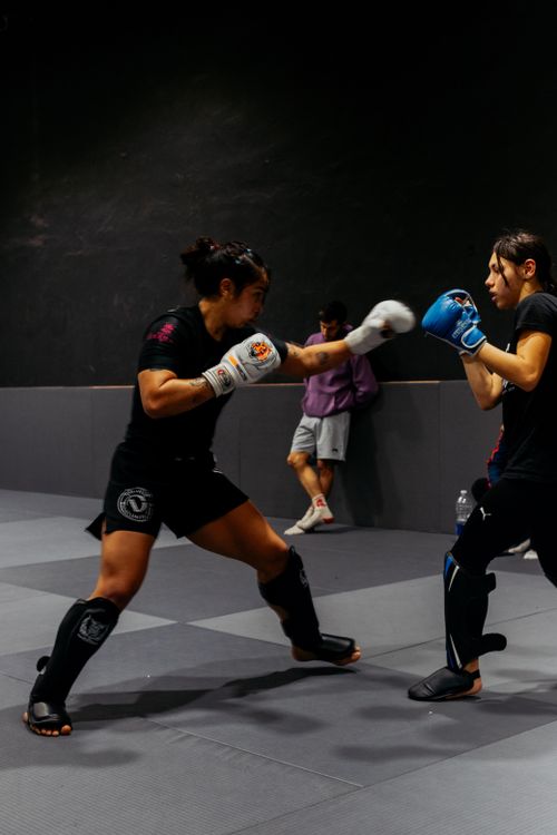 Free Two fighters sparring in a boxing gym under dim lighting, focusing on technique and agility. Stock Photo