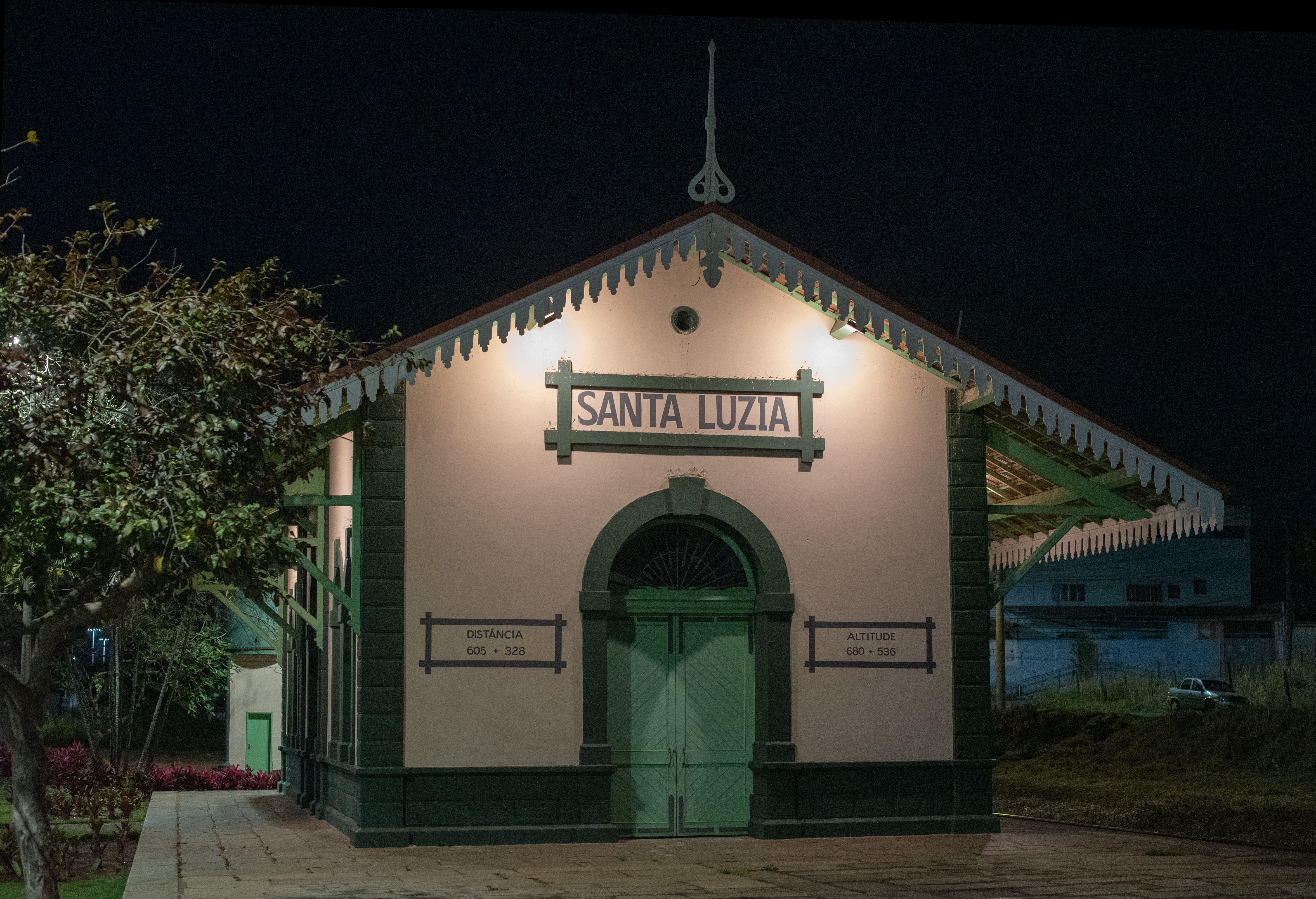 Illuminated Santa Luzia train station at night, showcasing classical architecture.