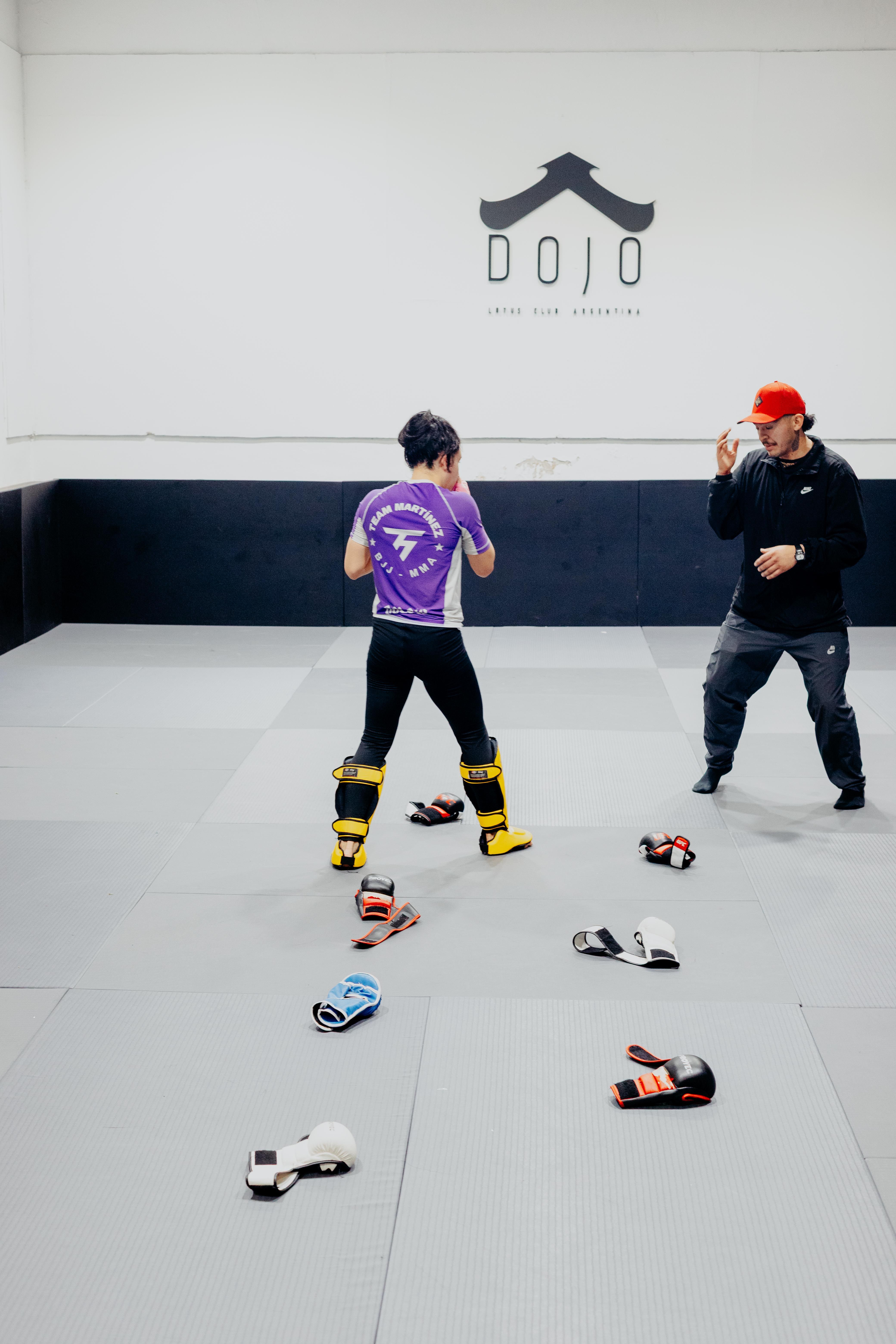 Two men practicing martial arts in a Buenos Aires dojo, focused on training techniques.