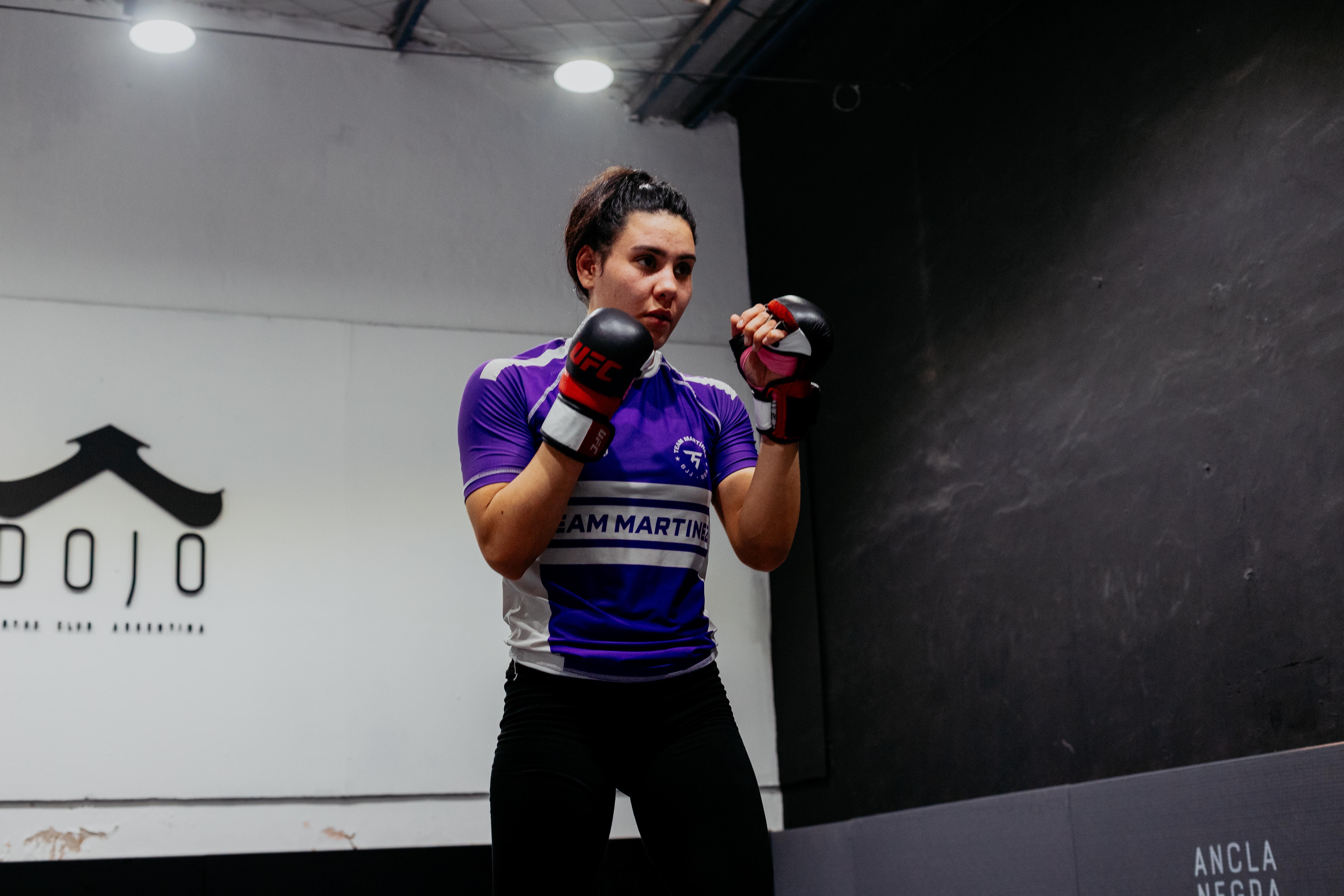Female martial artist practicing in a Buenos Aires dojo, showcasing mixed martial arts skills.