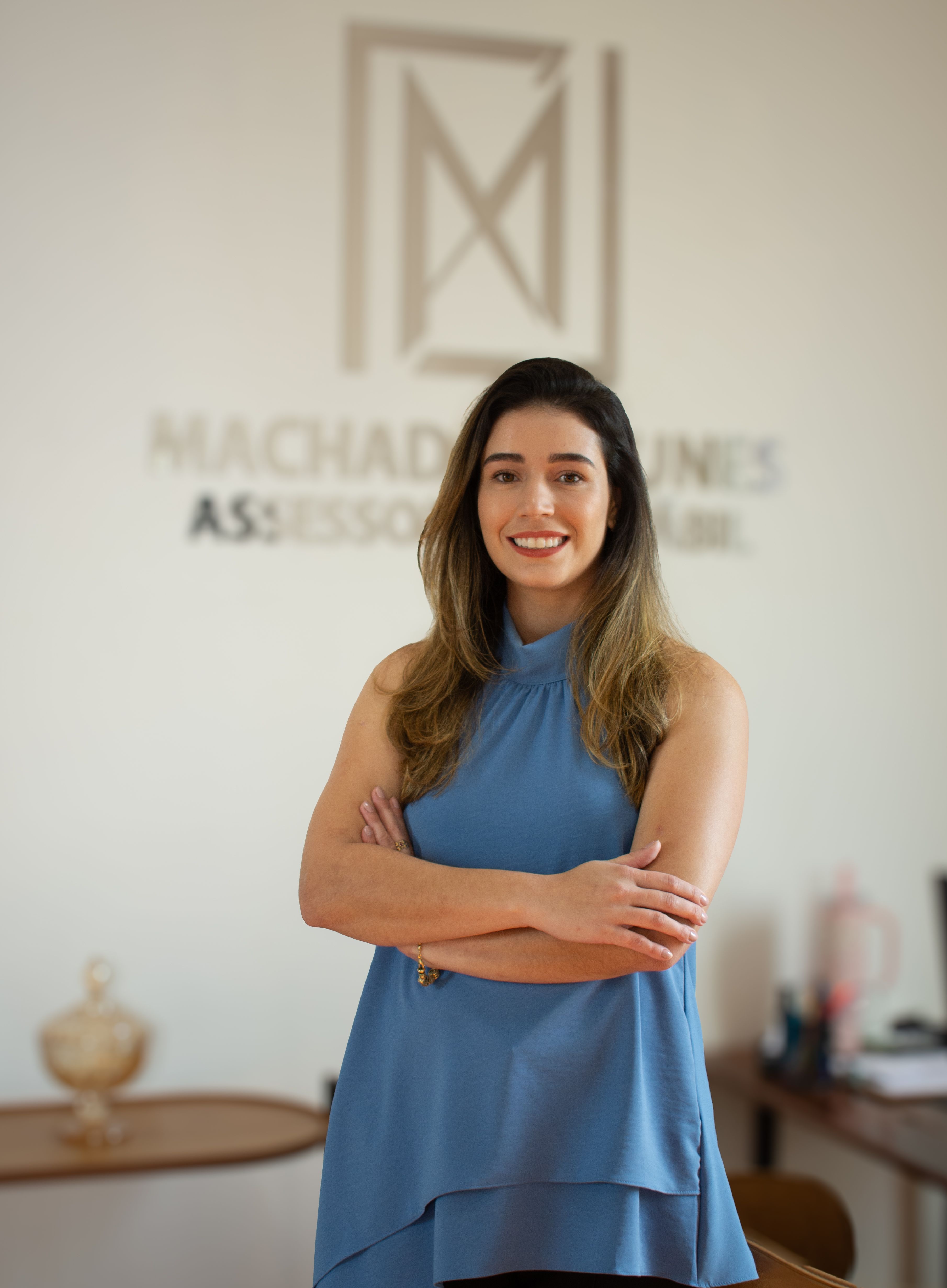 Confident woman in blue blouse in modern office, professional environment.