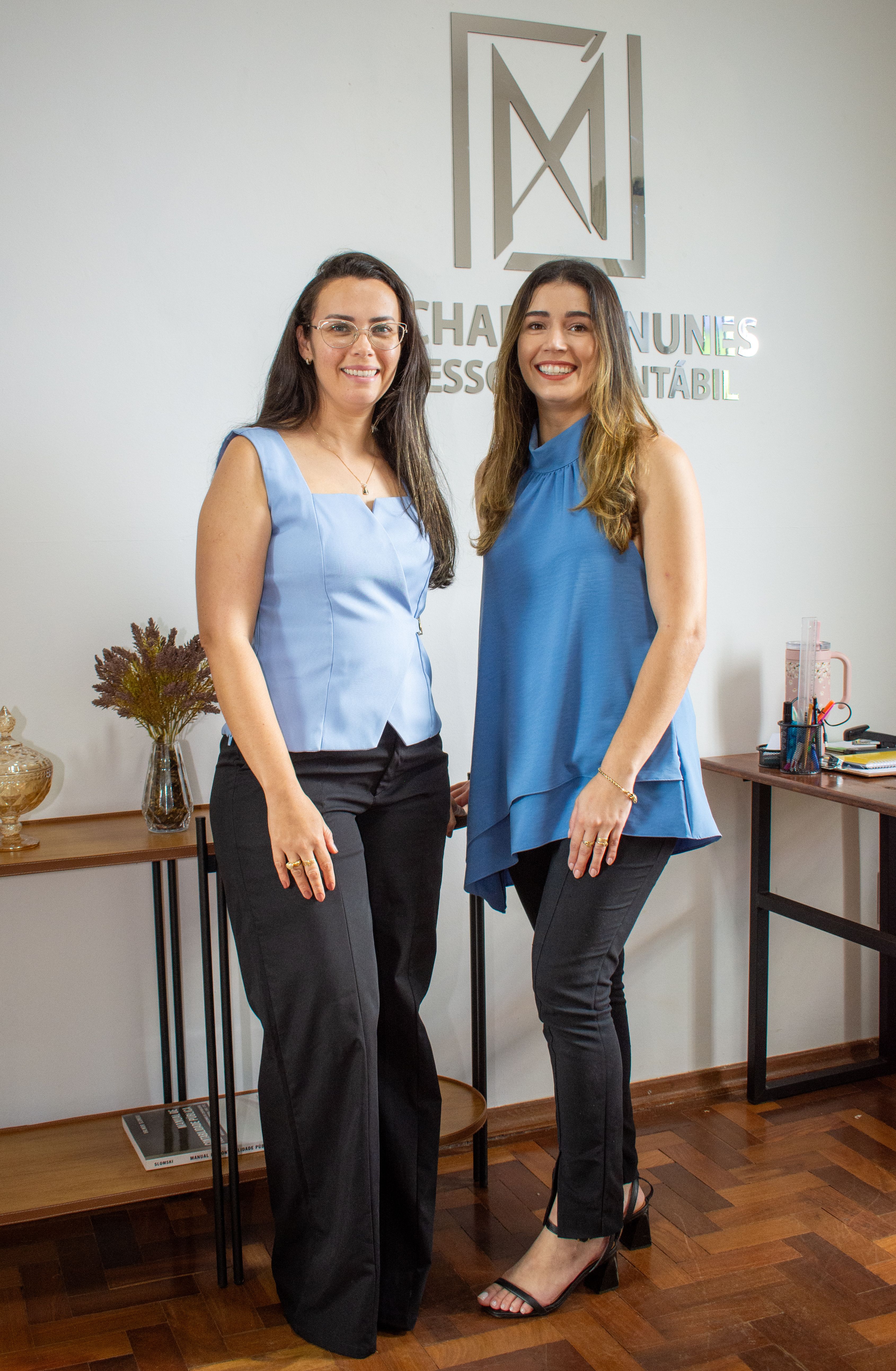 Two women in a professional office setting in Tiros, Minas Gerais, showcasing business attire and casual elegance.