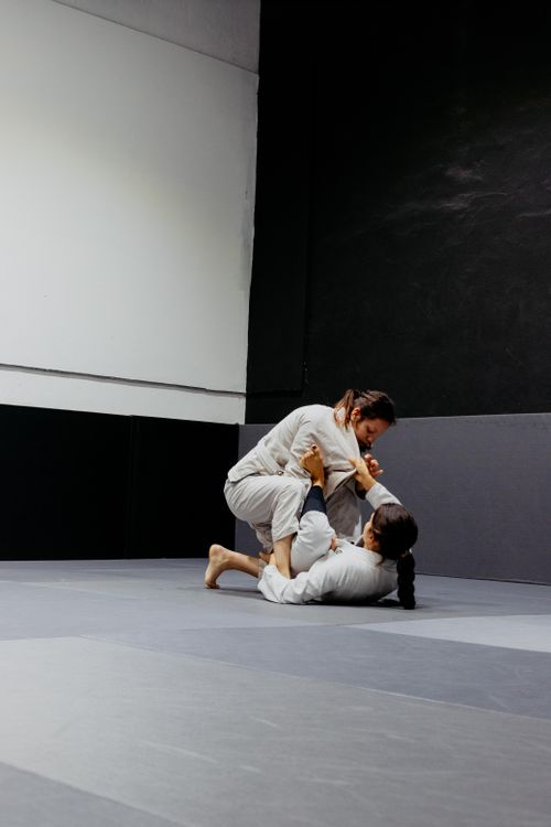 Free Two martial artists practicing Brazilian jiu-jitsu on an indoor mat. Stock Photo