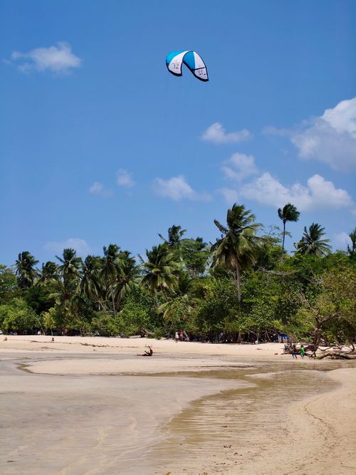 Free Kitesurfing on a tropical beach in Samaná, Dominican Republic, under a clear blue sky. Stock Photo