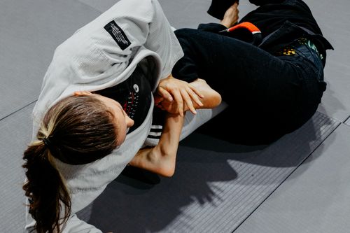 Free Two martial artists practicing jiu-jitsu grappling techniques indoors. Stock Photo