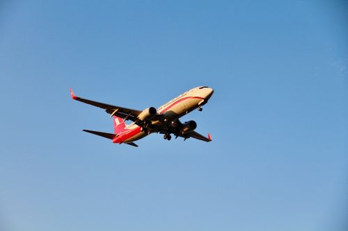 Free A commercial airplane captured mid-flight against a clear blue sky, showcasing aviation in action. Stock Photo