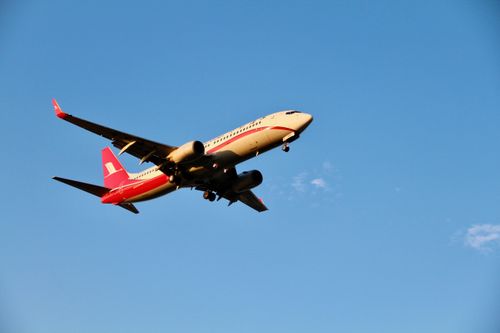 Free A commercial airplane flying low in a clear blue sky, showcasing aviation elegance. Stock Photo