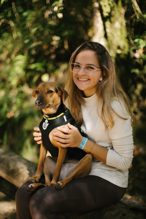 Free Happy woman with her dog enjoying a sunny day outdoors in a natural setting. Stock Photo