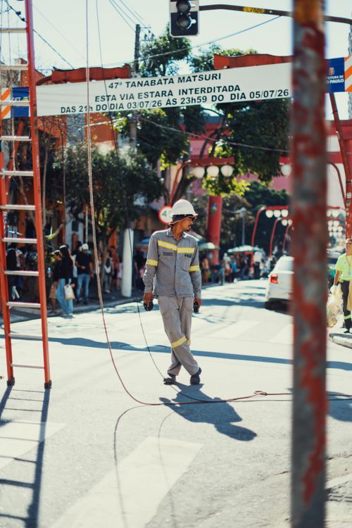 Free Construction worker in safety gear preparing for the Tanabata Matsuri Festival on a sunny day in the city. Stock Photo