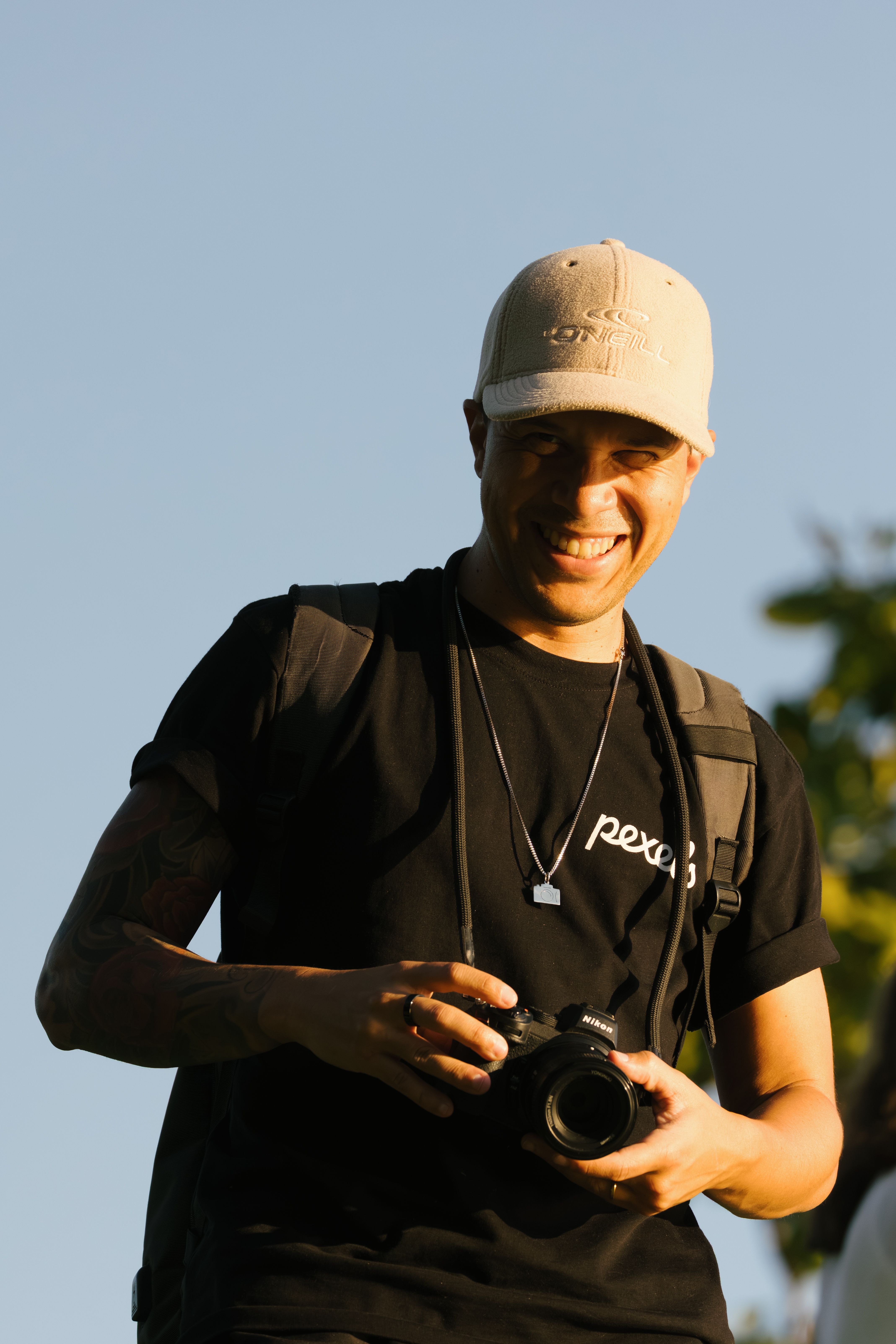 Energetic photographer enjoying a sunny day with his camera outdoors.