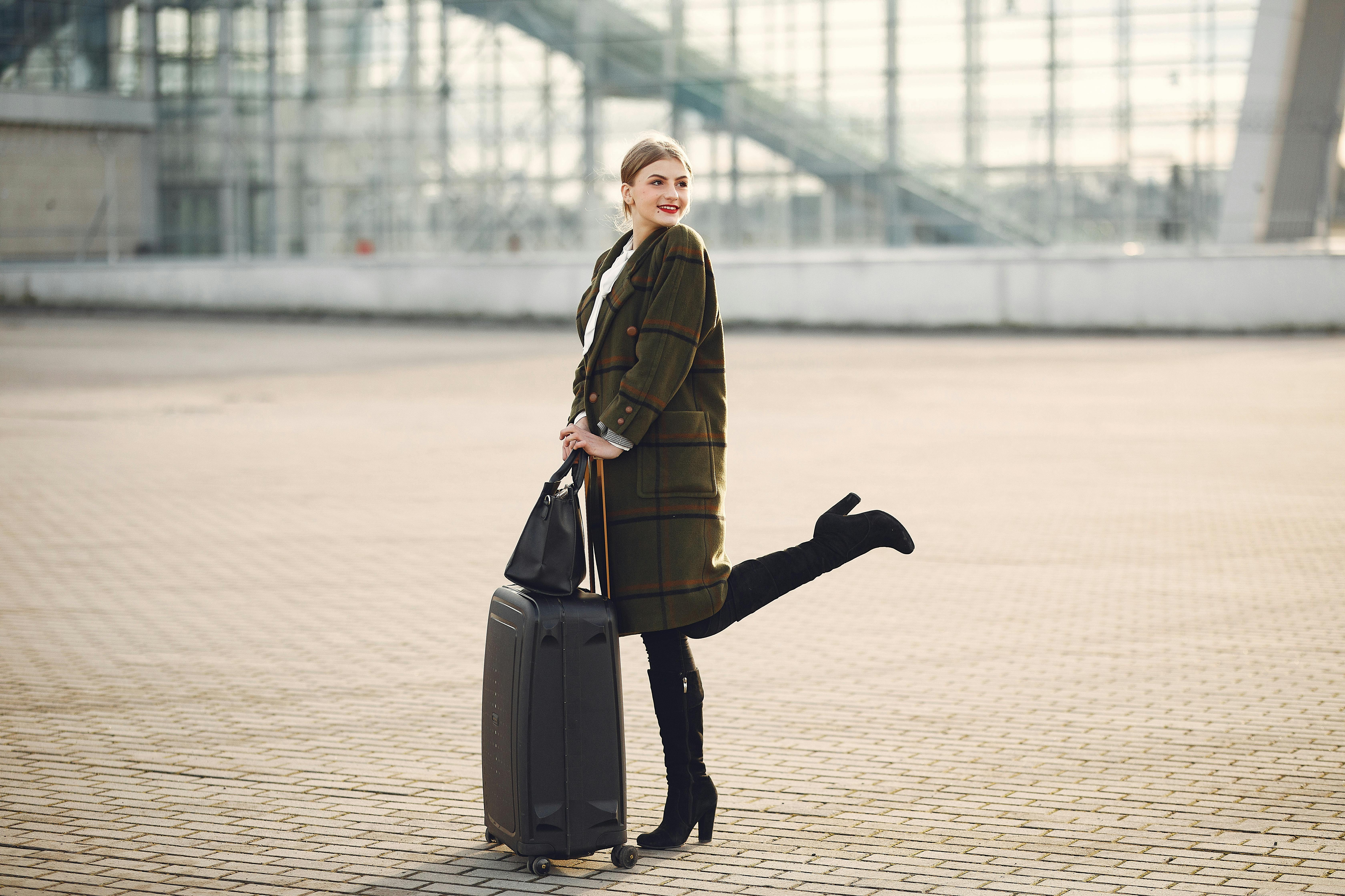 Elegant lady with baggage and bag next to airport Free Stock Photo