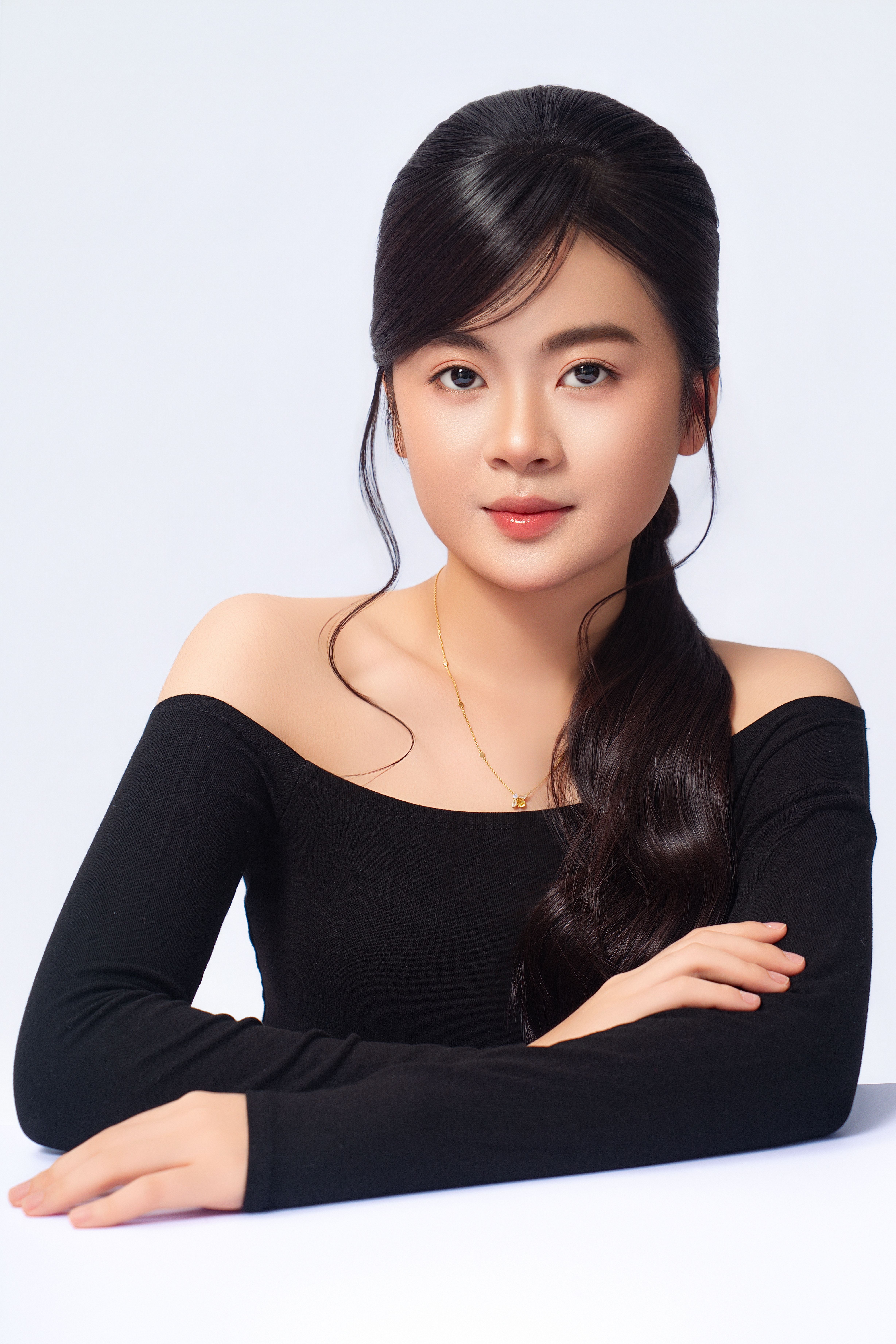 Studio portrait of a young Asian woman in a black top, exuding elegance and beauty.