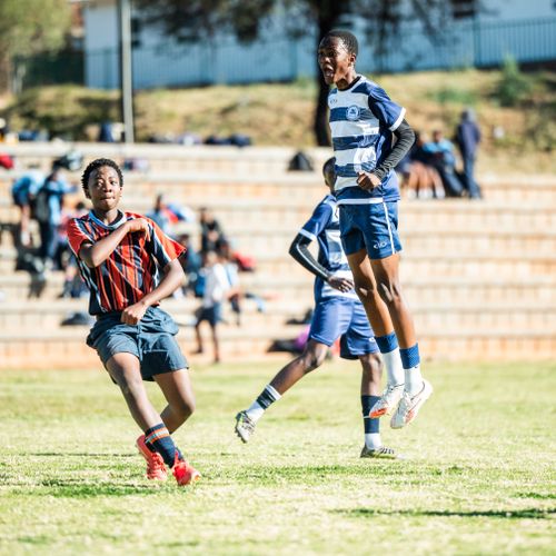 Free Energetic moment captured during a youth soccer match, showcasing players in action outdoors on a sunny day. Stock Photo