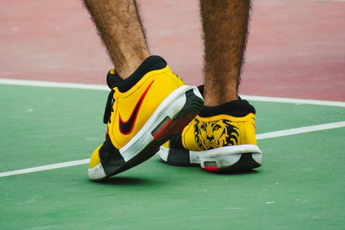 Free Vibrant yellow sport shoes on a colorful tennis court in Mexico City. Stock Photo