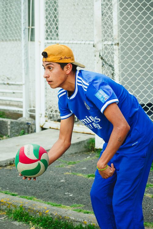 Free A young man prepares to serve a volleyball on an outdoor court in Ciudad de México, Mexico. Stock Photo