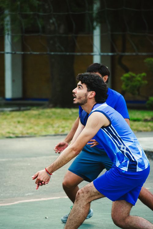 Free Dynamic action shot of young men playing volleyball outdoors in Mexico City. Stock Photo