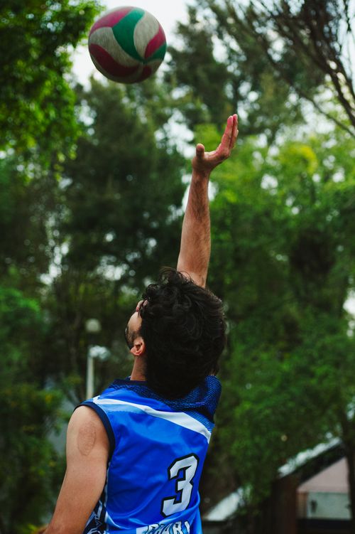 Free A volleyball player in a blue jersey performs a serve in an outdoor match. Stock Photo