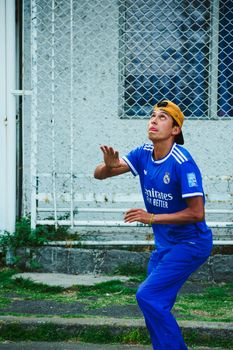 A young volleyball player in Mexico City preparing to hit the ball outdoors on a sports court.