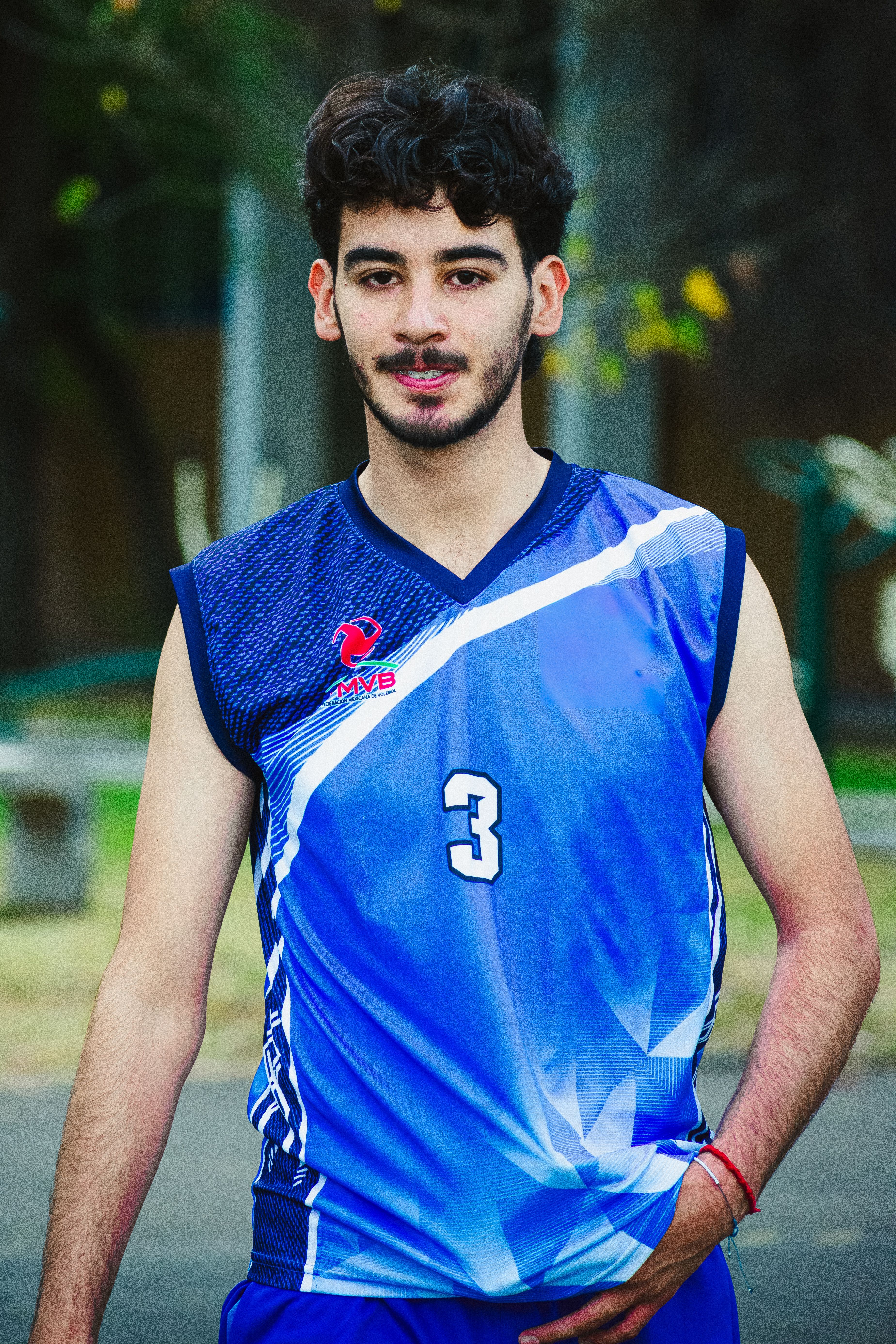 Portrait of a young male volleyball player wearing a blue uniform, outdoors in Ciudad de México.