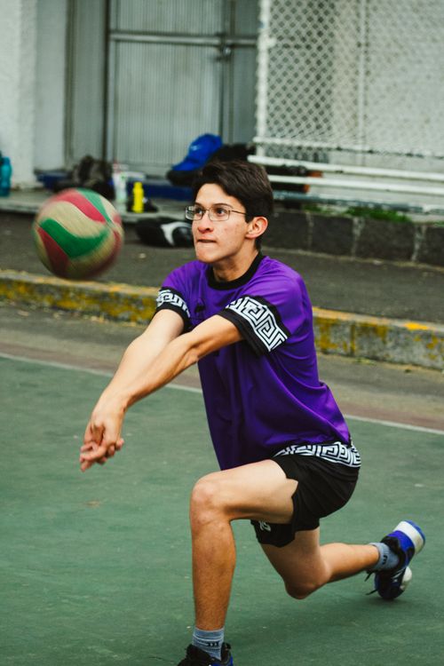 Free Energetic young man playing volleyball on an outdoor court in Mexico City. Intense focus and athleticism displayed. Stock Photo