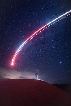 地平线上，星空下的人有醒目的光迹