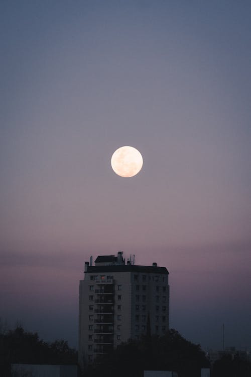 Free Full Moon Over White Concrete Building Stock Photo