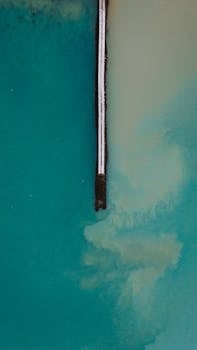 一个宁静的空中镜头展示了绿松石水域，码头构成了几何和谐