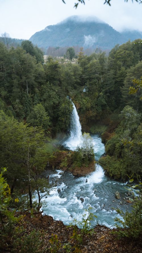 Free From above of splashing water cascade and lake among lush greenery in mountains Stock Photo