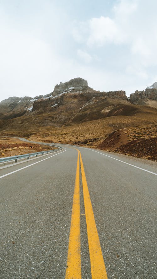 Kahverengi Dağ Yakınındaki Gri Beton Yol