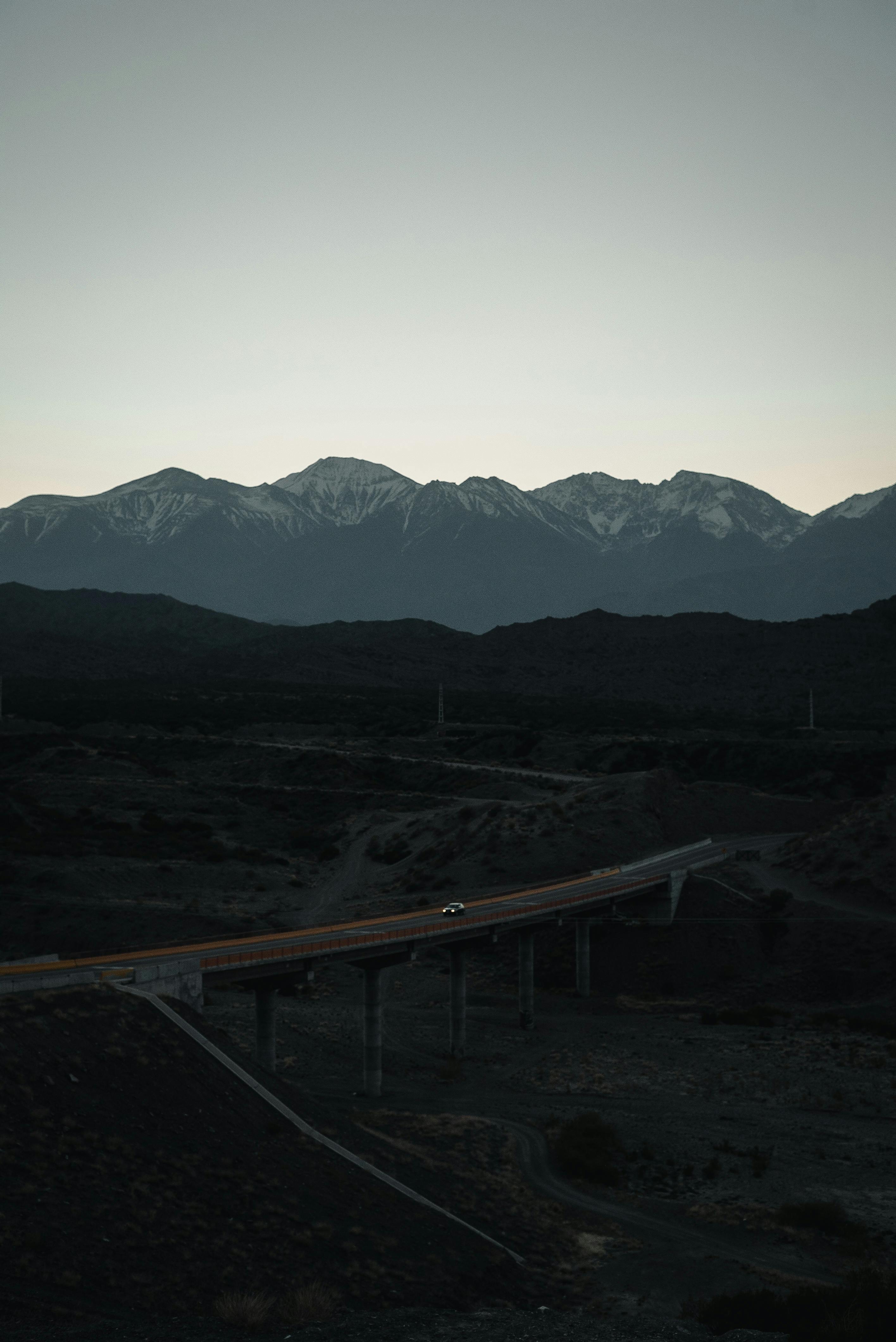 ridge near roadway with driving car in evening