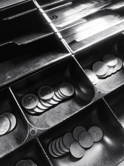 Black and white photo of cash drawers holding coins and bills in a classic register. Black and white photo of cash drawers holding coins and bills in a classic register.