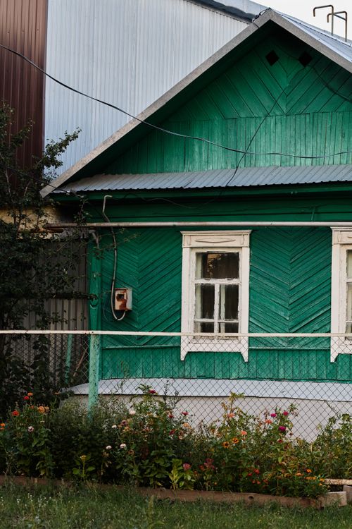 Free Green wooden house with garden accentuated by colorful flowers. Stock Photo