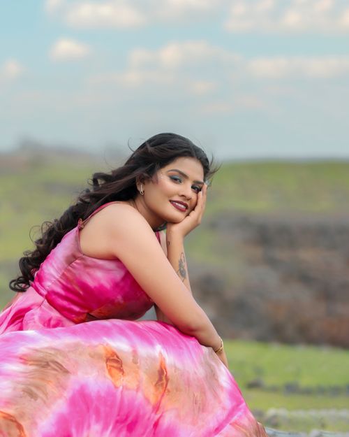 Free Smiling woman in a vibrant pink dress enjoying a sunny day outdoors. Stock Photo
