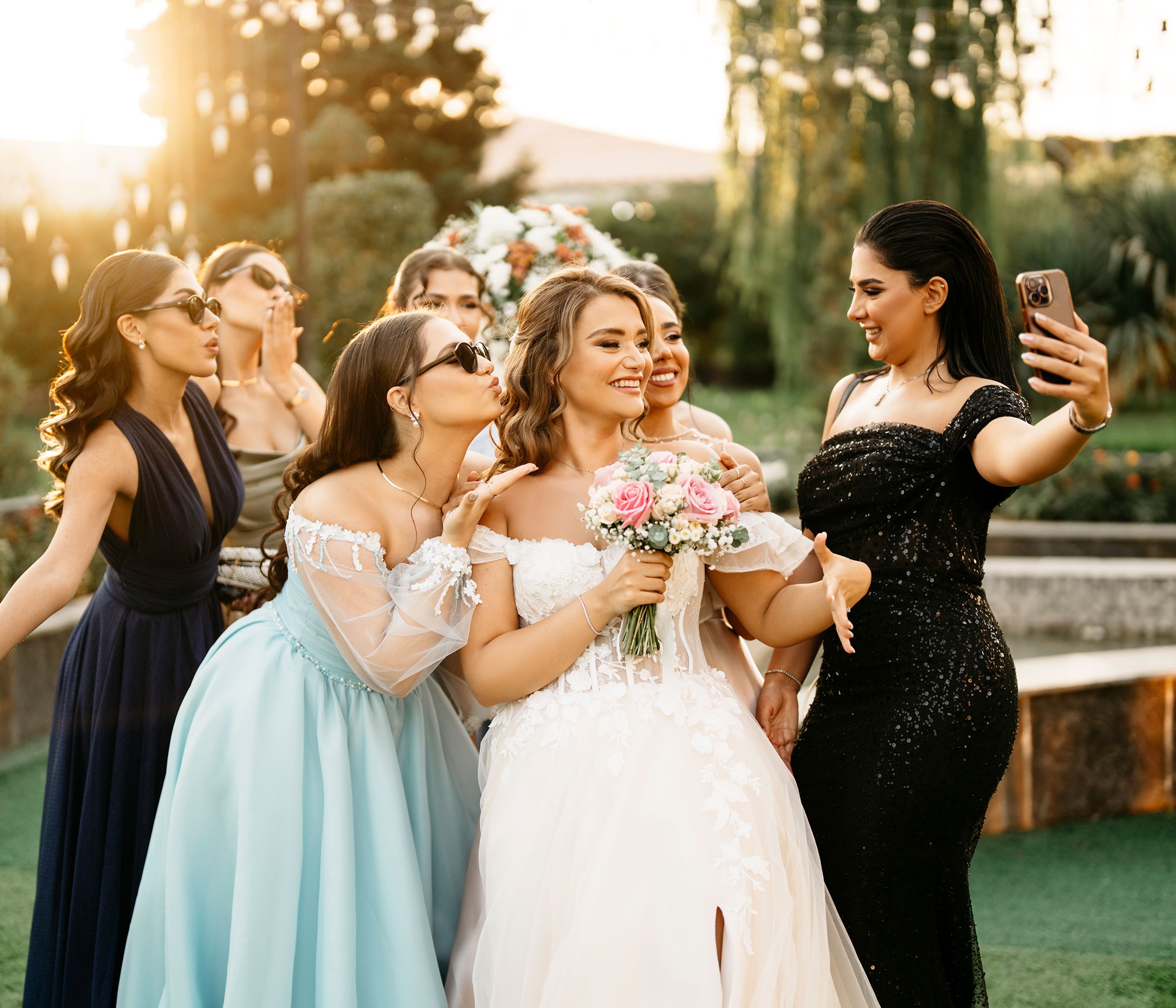 Bride and bridesmaids celebrate in an outdoor wedding selfie full of joy and elegance.