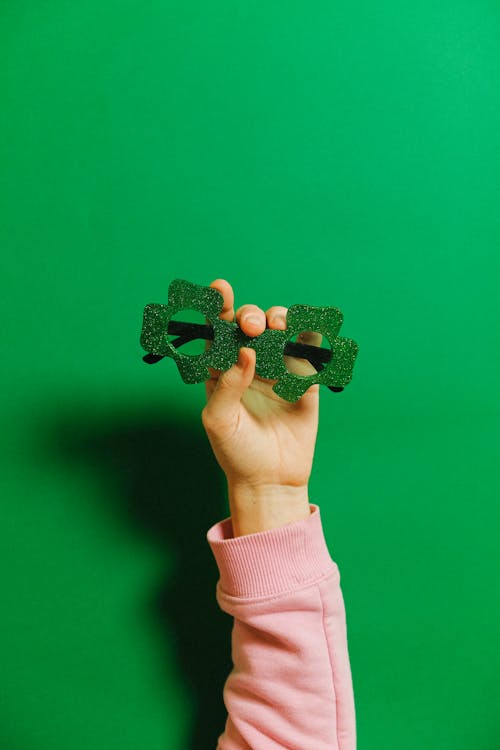 Person Holding Green Glasses
