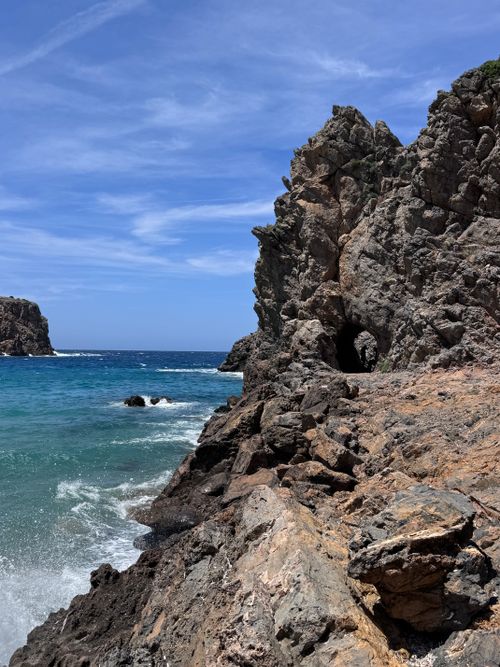 Free Rugged Sardinian cliffs with a vivid blue sea under clear skies. Perfect for travel and nature lovers. Stock Photo