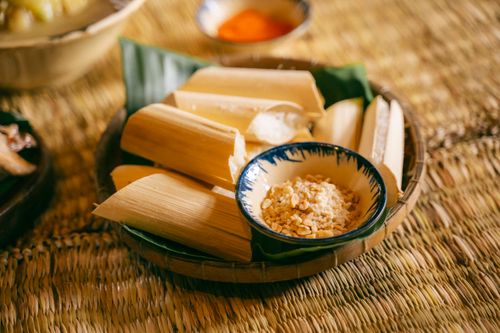 Free Delicious traditional bamboo rice served with peanuts on a woven mat, showcasing Asian culinary culture. Stock Photo